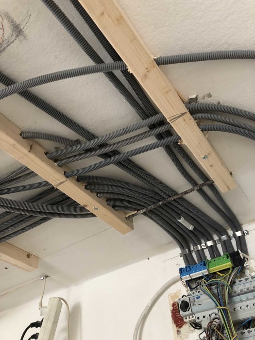 Elledningar dragna genom böjbara rör fästa vid takbjälkar och elcentral.