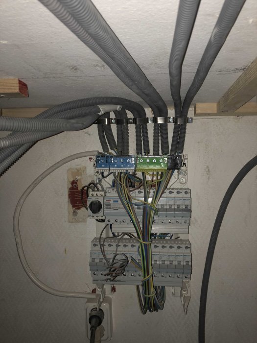 Elcentral med öppen kabeldragning och elektriska ledningar i flexibla rör monterade i taket.