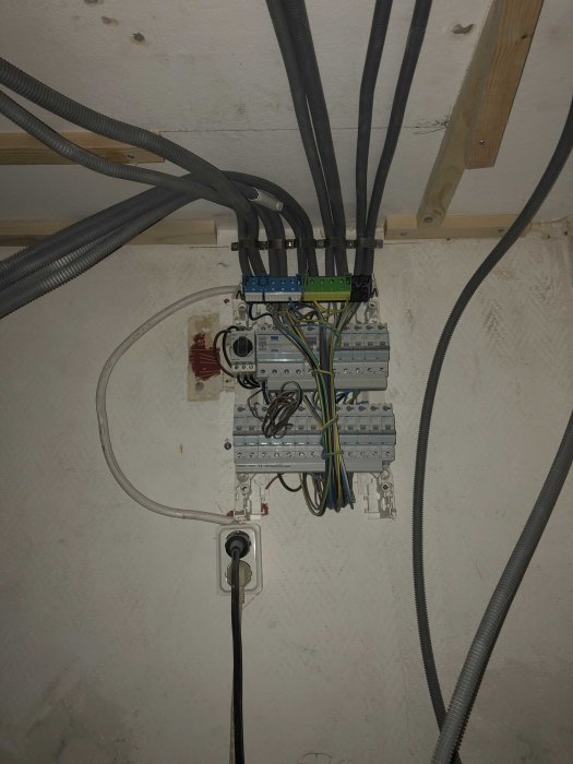 Elcentral under konstruktion med oskyddade kablar och omonterade säkringskomponenter.