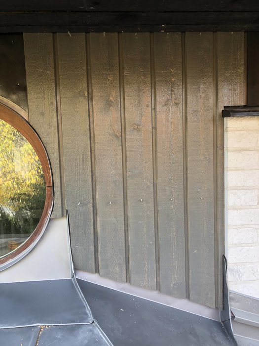 Nyinstallerad silvergrå panel vid entré med målat överbleck och nytt takbleck.