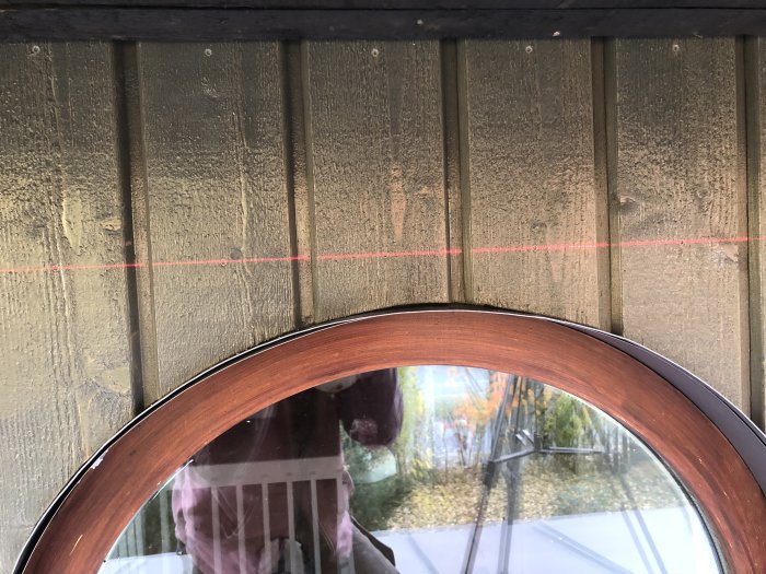 Användning av laser för att markera en rak linje ovanför ett fönster vid byggarbete.
