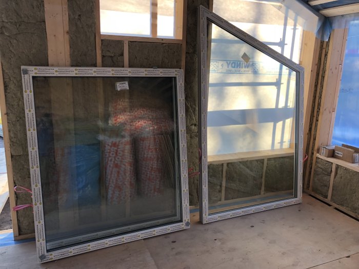 Nya isolerade väggar med synlig stomme och inramade, levererade fönster i ett renoveringsprojekt.