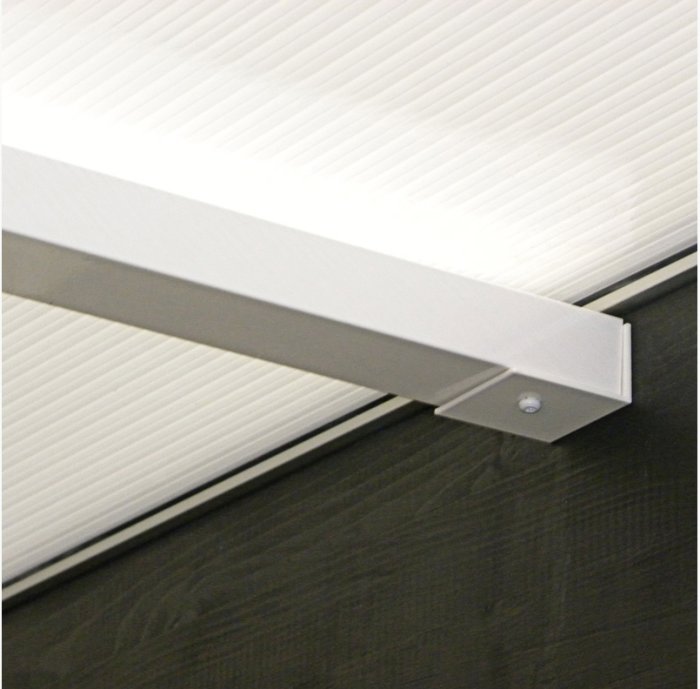 Vit fönsterlister mot en ribbad vit takyta och mörkt trägolv.