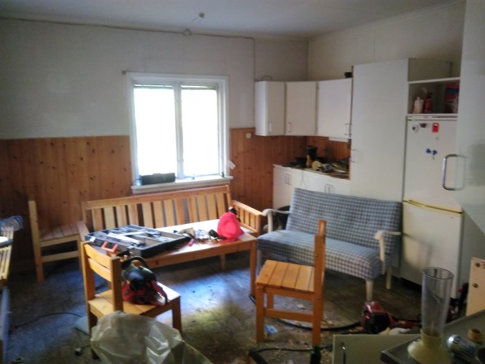Ommöblerat kök under renovering med befintliga skåp och köksbänk intill vägg föreslagen för rivning.