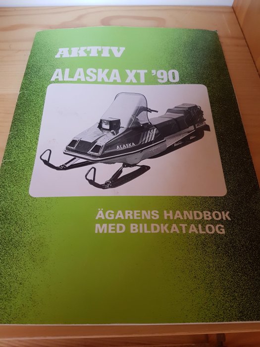 Manual för AKTIV Alaska XT '90 skotern, ägarens handbok med bildkatalog på omslaget.