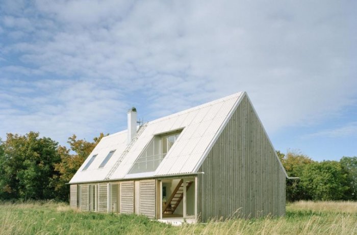 Mattias Palmes ladhus med lutande tak, vita väggar och träinredning på Fårö, omgiven av natur.