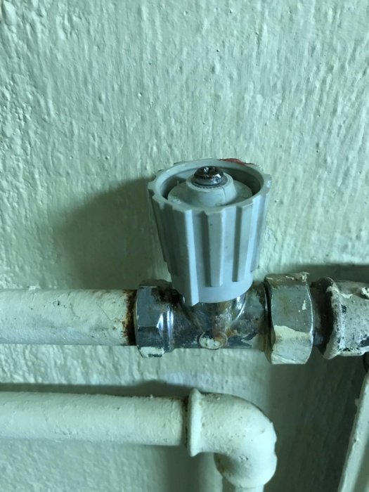 Läckande termostat på radiator med synliga droppar och korrosion, vredet avtaget.