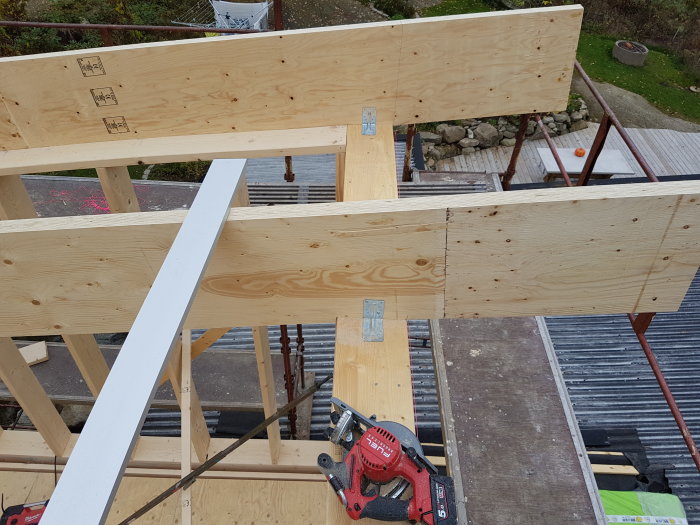 Träreglar och takstolar i en byggställning på andra våningen av ett hus under konstruktion.