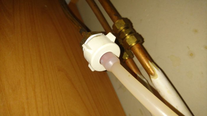 Öppen vattenkrananslutning med kopplade rör, vars felinställning påverkar varmvattnet i huset.