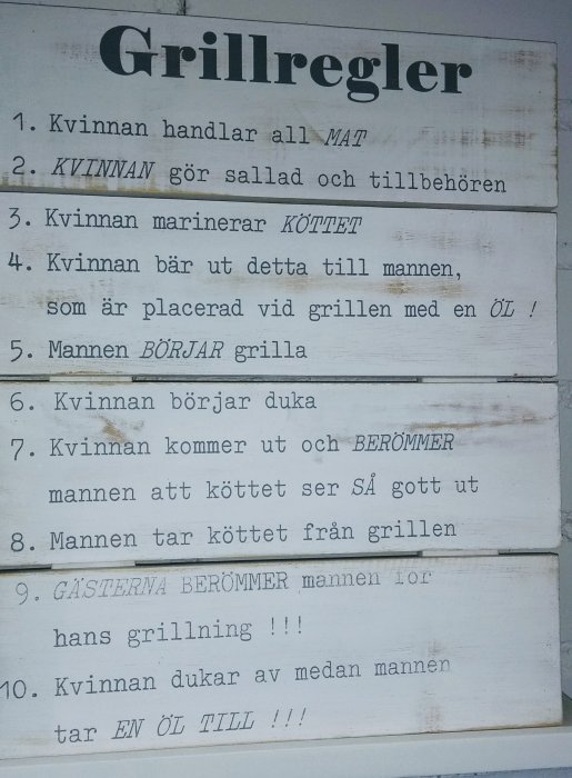 Vit träskylt med humoristiska "Grillregler" som beskriver könsstereotypa uppgifter vid grillning.