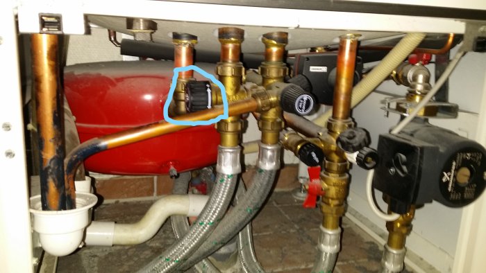 Blandningsventil i fokus omgiven av rör och ventiler under en panna, misstänkt för felaktig justering.