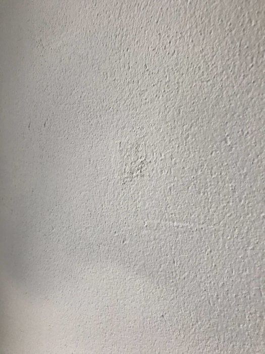 Ojämn putsad yta på vägg, troligen i behov av bättre spackling och finish.