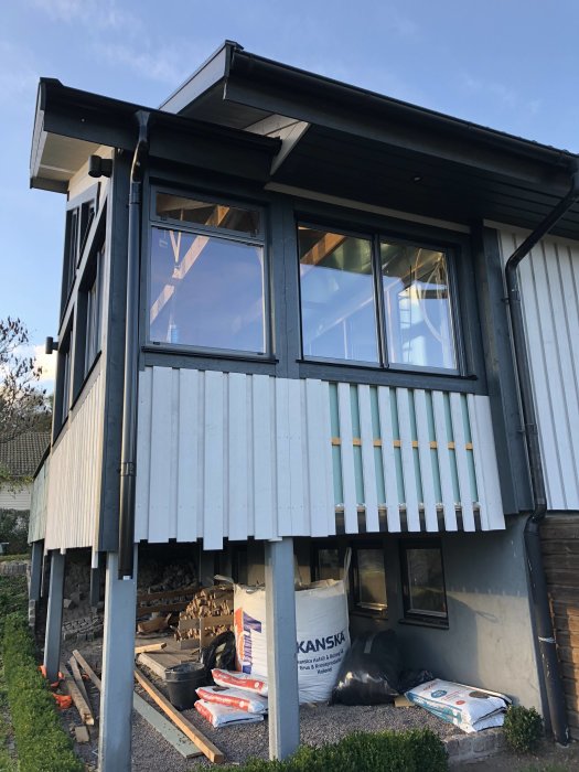 Husfasad med fönster, stuprör och yttre renovering, framtida ingångsplats för katt anges.