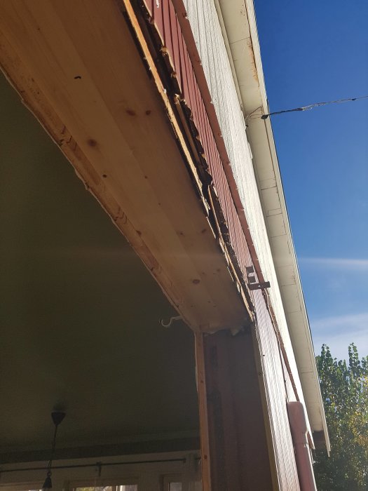 Upprivet fönsterområde i väntan på installation av nytt fönster, synliga reglar och plywood.