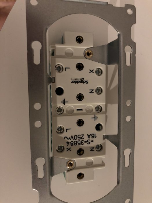 En hörnbox för elinstallation med synliga L, N och jordanslutningar.