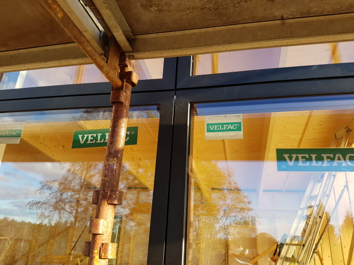 Nyinstallerade Velfac-fönster i en byggnad med skyddande presenning och konstruktionsmaterial synliga.