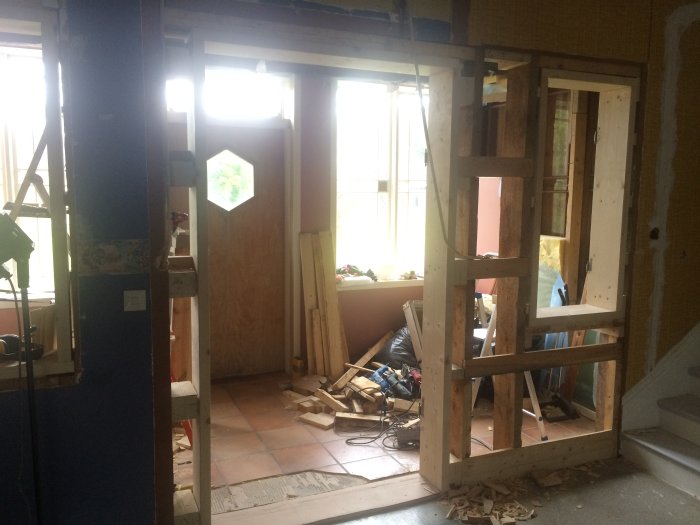 Bild på ett pågående renoveringsprojekt i ett äldre hus med träreglar och byggmaterial.