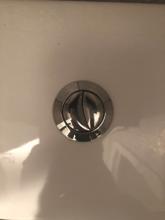 Metallmärkning på möbel med möjlig text P4 eller B4, svårt att se i trångt utrymme.