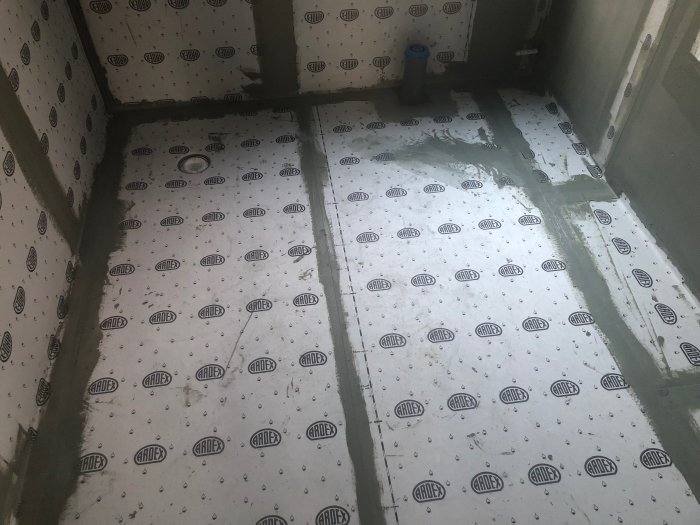 Fuktisolering med ARDEX-logotyp i ett pågående husbyggprojekt.