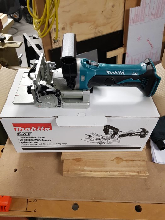 Makita DPJ180z batteridriven lamellfräs uppackad ur lådan på ett arbetsbord.