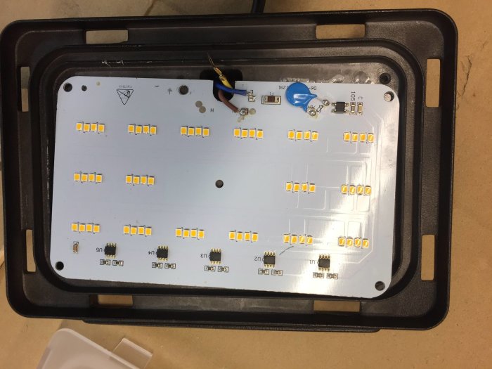 Öppen LED-armatur med synliga lysdioder och kretsar på en aluminiumplåt, redo för anpassning med ny gummikabel.