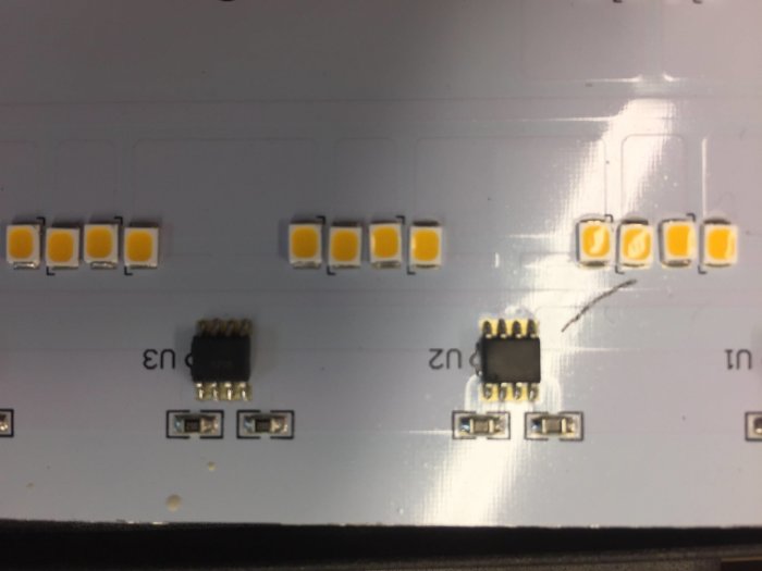 Närbild på en LED-belysningskomponents kretsar och dioder på en aluminiumplåt.