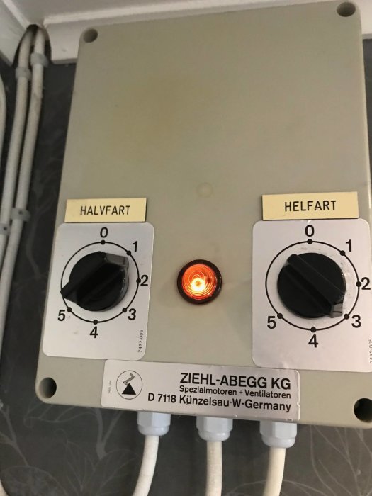 Regulator för ventilationshastighet märkt 'HALVFART' och 'HELFART' med tänd varningslampa.