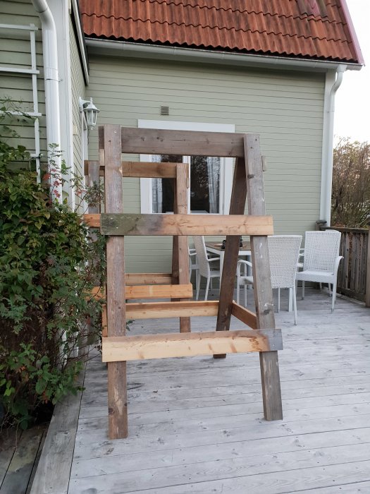Hemmagjorda högbockar av återanvänt ställningsvirke på en träveranda.