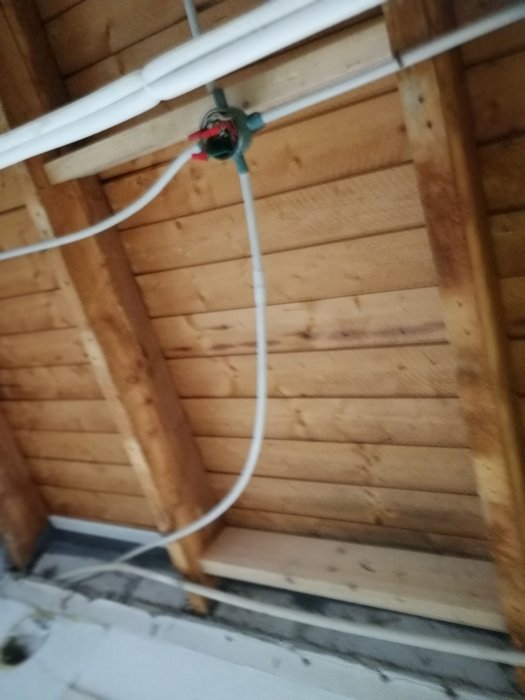 Renovering av tvättstuga med nya elrör monterade längs träreglar och isolering.