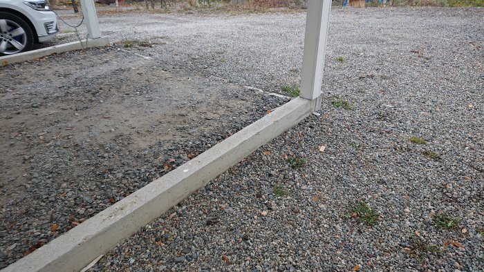 Betongsockel vid en carport med grusgolv som förbereds för gjutning och isolering.