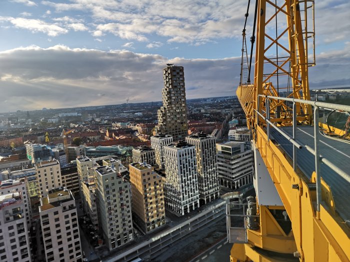 Vy över stad med byggnader och en byggkran som indikerar starten av ett nytt tornprojekt.