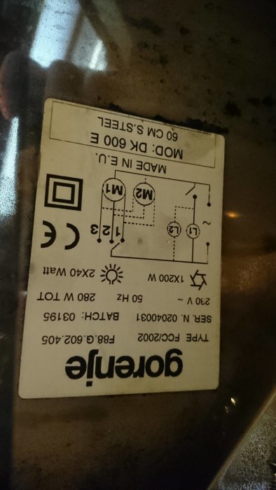 Upp och nervänd bild av en elektrisk apparats etikett med schematiska symboler och tekniska specifikationer.