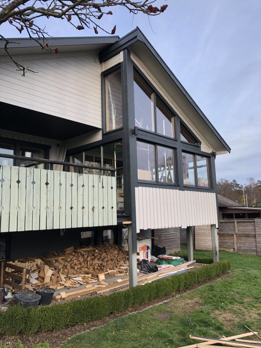 Hus under renovering med ny panel under takutskjut och påbörjat arbete under uterum.