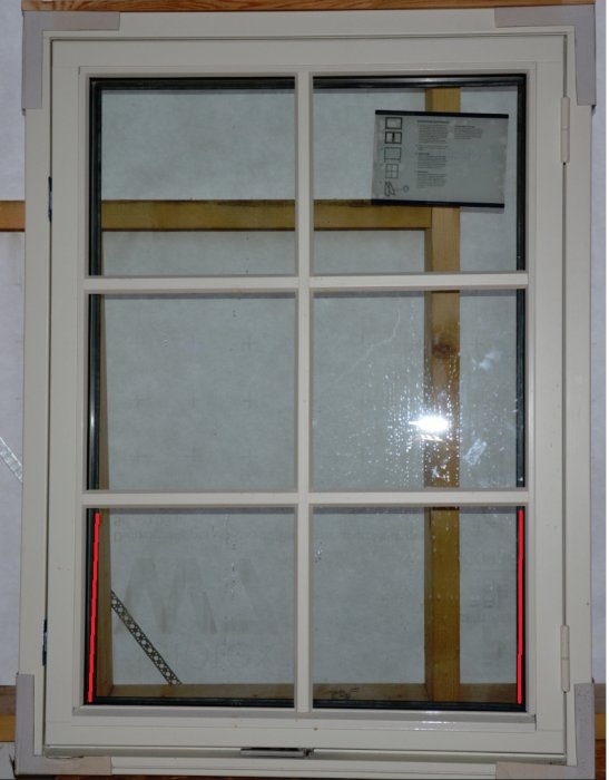 Felmonterat fönster med skeva och ojämnt placerade spröjs markerade med röda linjer, vilket illustrerar kvalitetsproblemen.