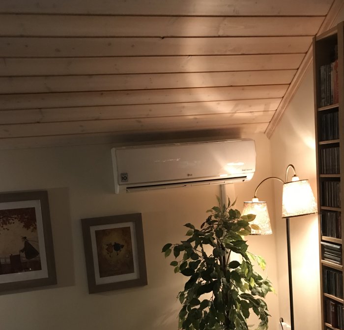 Nyligen installerad Libero 12 luftvärmepump på vägg i ett trivsamt rum med träpanel i taket.