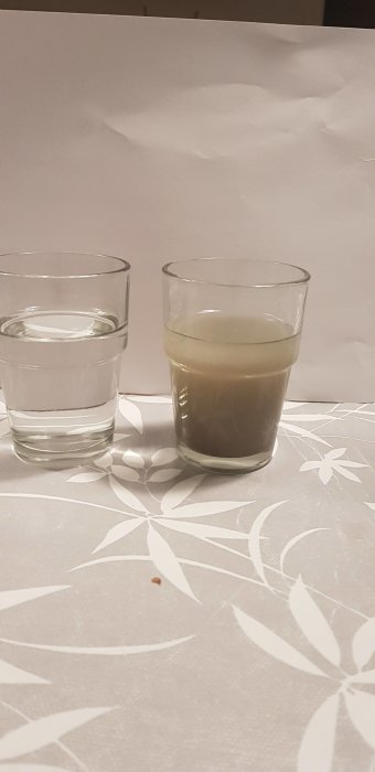 Två glas på bord, ett med klart vatten och ett med gråsvart smutsigt vatten, illustrerar vattenkvalitet från brunn.
