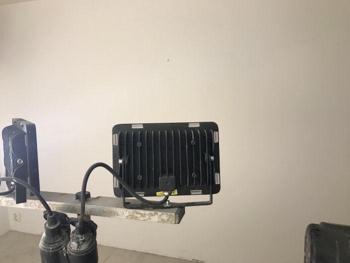 Två avstängda LED-paneler för indirekt belysning, 50W till vänster och 100W till höger, monterade på vägg.