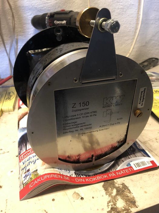 Dragbegränsare Z150 på ett bord med märkning och information, Cocraft borr i bakgrunden.
