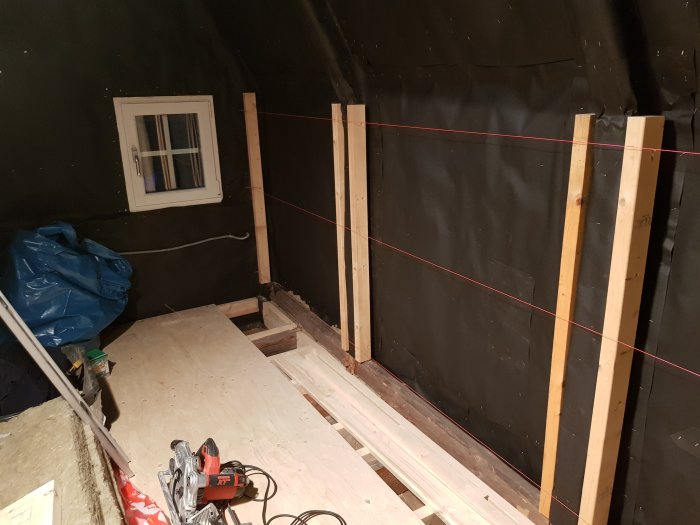Renoveringsarbete med laserlinjer för att rikta upp väggar och tak i ett pågående byggprojekt.
