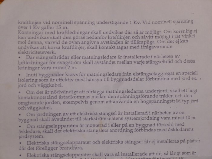 Fotografi av en sida ur en bruksanvisning som behandlar elinstallation och säkerhetsavstånd.