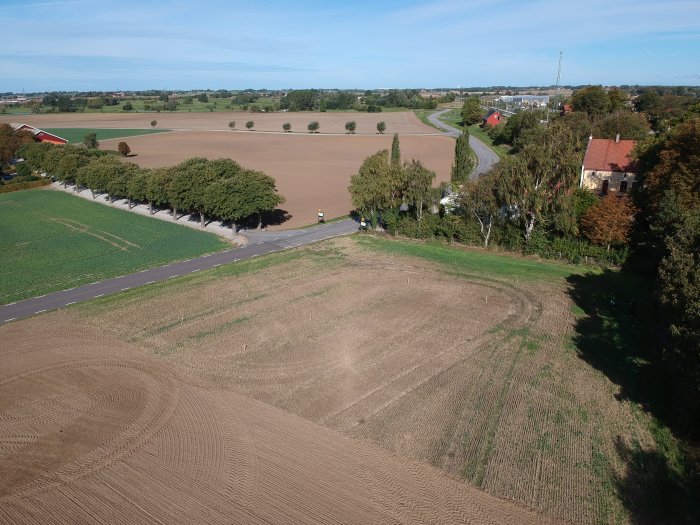 Flygfoto över ett landskap med jämnad mark för beredning inför byggnation, högar av jord syns.