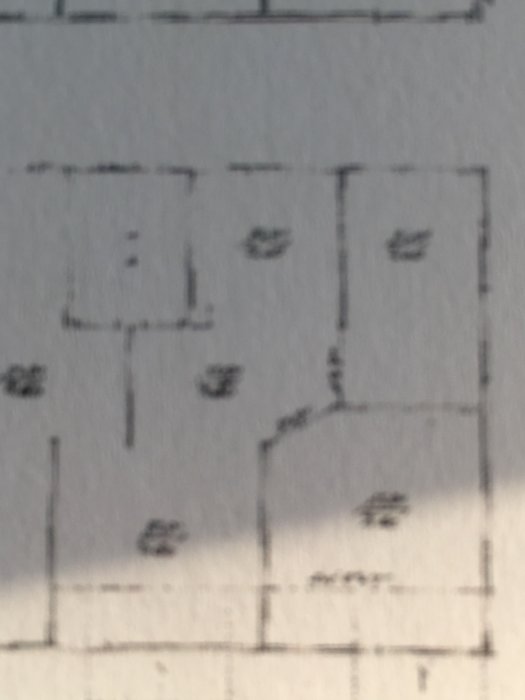 Suddig närbild av en del av en bjälklagsritning med rödmarkering som inte finns med på ritningen.