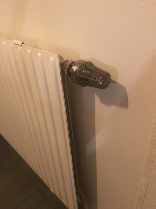 Radiatortermostat som indikerar ett eventuellt enrörssystem på en vit värmeelement.