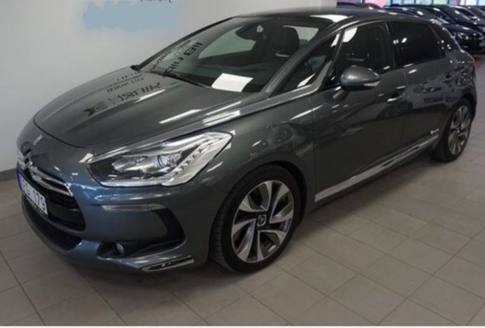 Grå Citroën DS5 parkerad på ett bilförsäljningsgolv.