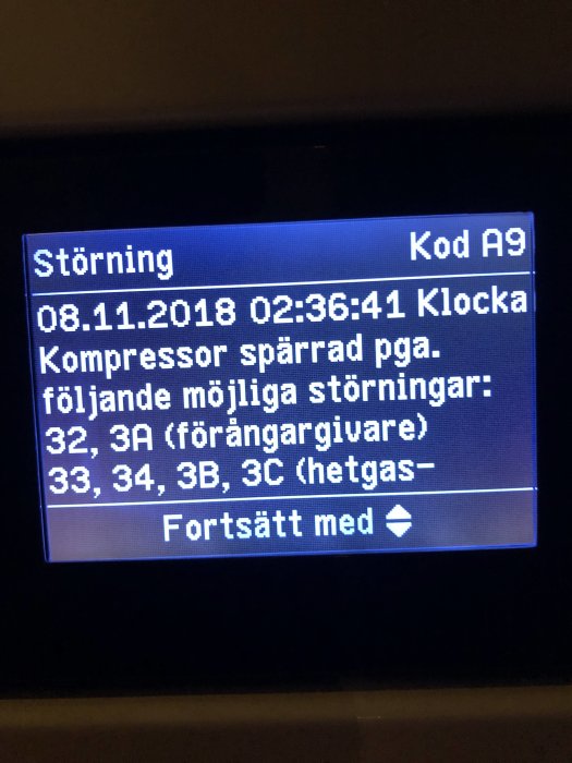 Display på en bergvärmepump som visar en felkod A9 och möjliga orsaker till störningen.