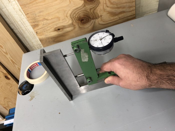 Hand som justerar en Hultafors PS120 ställbar gipsvinkel med en precisionsmätare på ett arbetsbord.