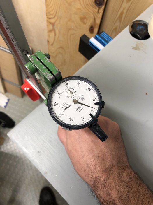 En hand som håller ett mätinstrument för att kalibrera en hörnvinkel på en ställbar gipsvinkel.