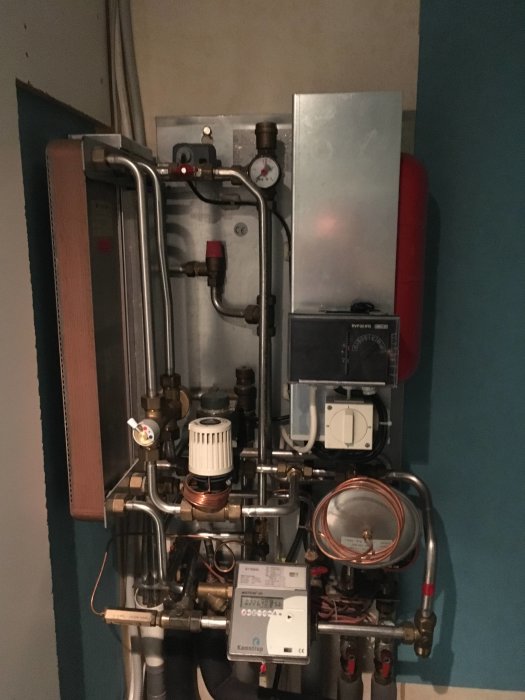 Värmesystem med rör, mätare och ventiler för justering av vatten- och värmetemperatur i hus.