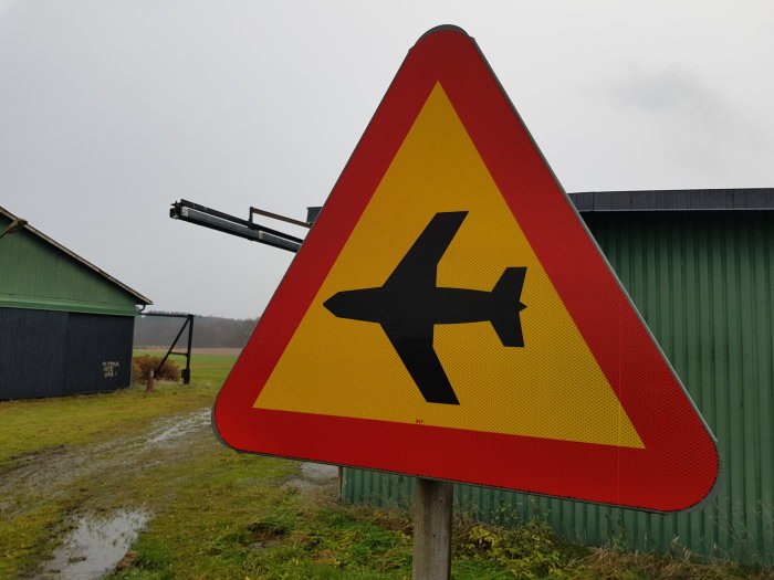 Varningsskylt med flygplanssymbol indikerar lågt flygande flygplan.