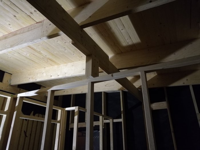 Limträbalkar och reglad innervägg i en tvåfackskonstruktion på ett pågående bygge.